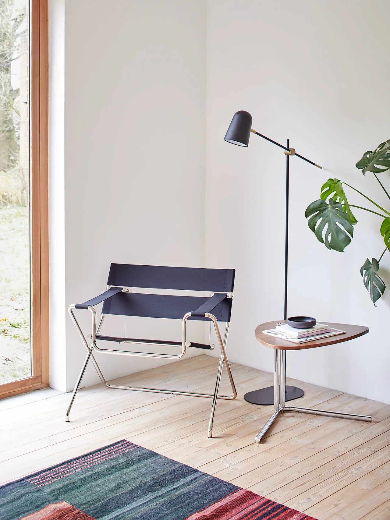 Modernes Wohndesign: Faltbarer Sessel Tecta D4 in heller, gemütlicher Umgebung mit Teppich, Holzboden und Pflanze