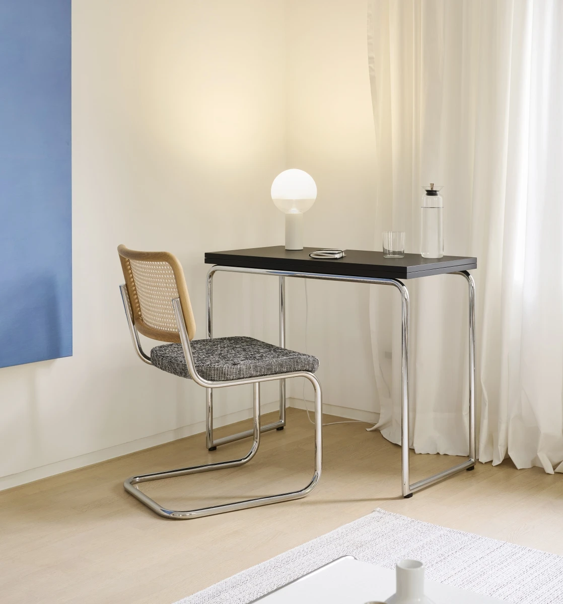 Thonet B 109 Klapptisch schwarz Interieurbild mit Lampe, Freischwinger, Teppich und Vorhang